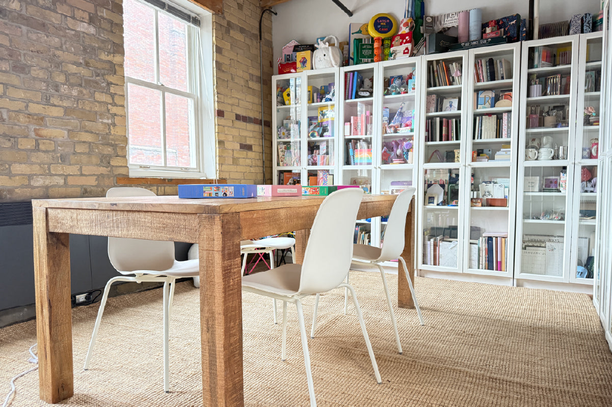 The Hobbry Studio area with wooden table and chairs in front of a bookshelf.