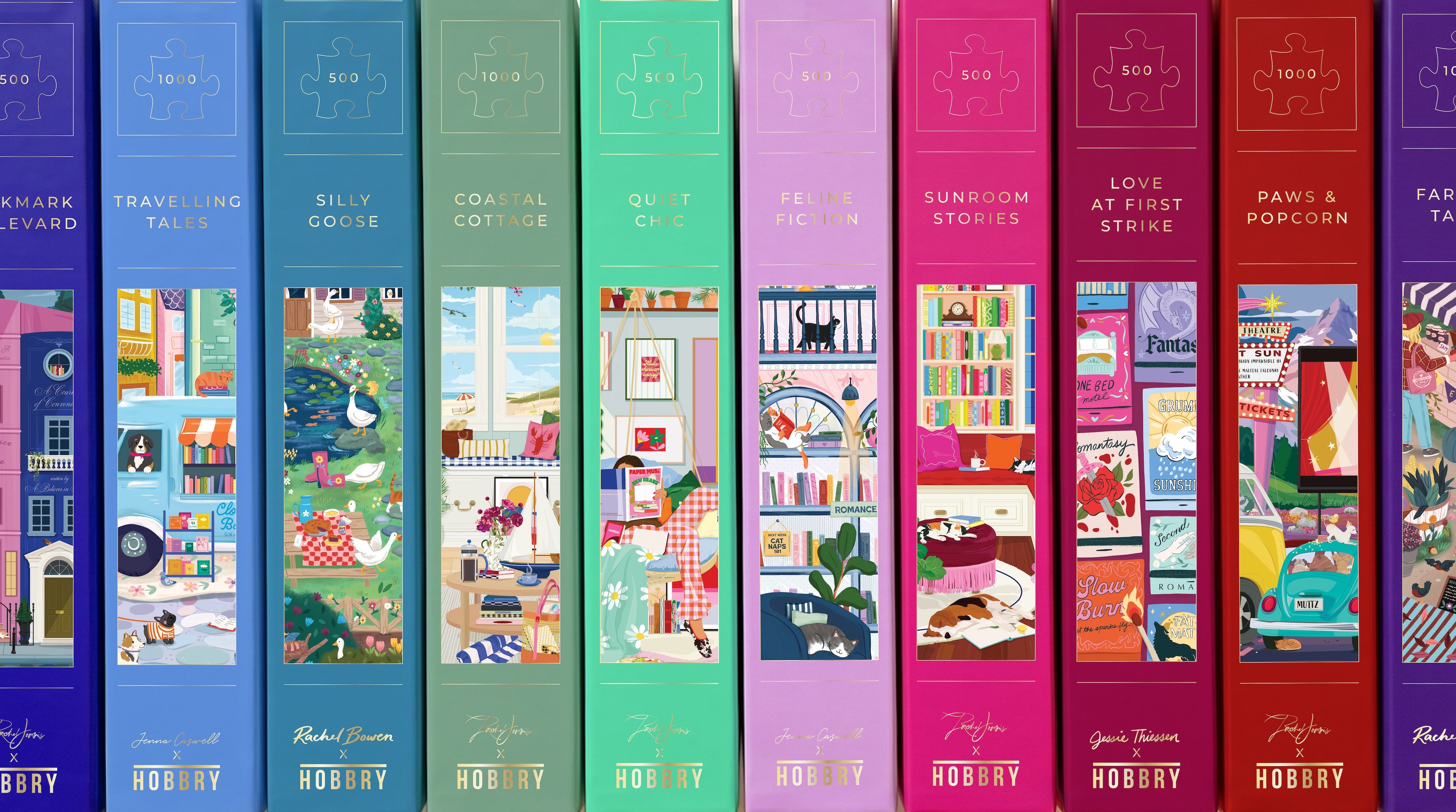 A row of colorful jigsaw puzzle boxes arranged side by side on a white background. Each box has a different bright color and illustrated cover showing a themed puzzle scene, with titles such as Travelling Tales, Silly Goose, Coastal Cottage, Quiet Chic, Sunroom stories Love at First Strike, Paws & Popcorn.